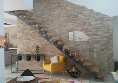 Niederbronn : escalier limon central en acier laqué, marche en hêtre et garde-corps full verre sans poteaux