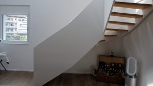 Escalier design entre limon sans fixation visible, garde-corps en prolongement du limon laqué en blanc