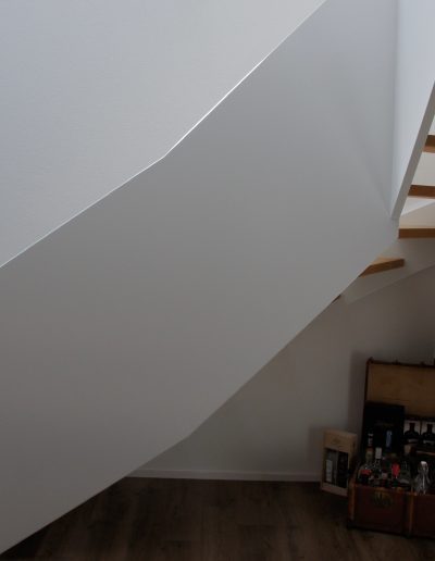 Escalier design entre limon sans fixation visible, garde-corps en prolongement du limon laqué en blanc