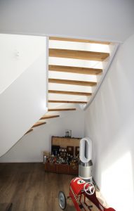 Escalier design entre limon sans fixation visible, garde-corps en prolongement du limon laqué en blanc