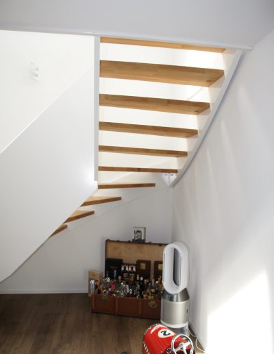 Escalier design entre limon sans fixation visible, garde-corps en prolongement du limon laqué en blanc