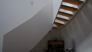 Escalier design entre limon sans fixation visible, garde-corps en prolongement du limon laqué en blanc