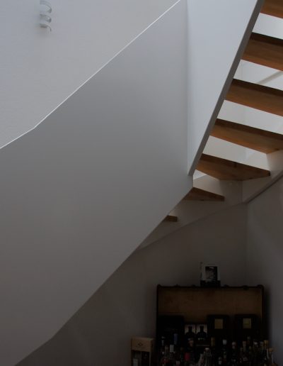 Escalier design entre limon sans fixation visible, garde-corps en prolongement du limon laqué en blanc