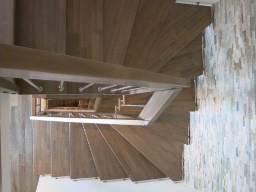 Strasbourg : escalier suspendu deux quart tournant sur plot inox avec balustres verticales et marche en hêtre teinté massif
