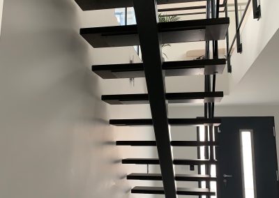 Haguenau : escalier limon central en acier laqué noit et marche teintés, garde-corps avec verre et acier plat