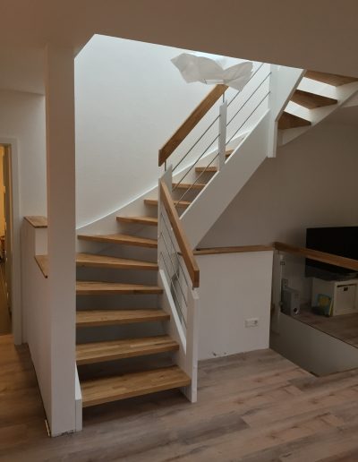 Escalier traditionnel avec limon en bois blanc, marche en chênes, main courante en bois et tige horizontale en inoc