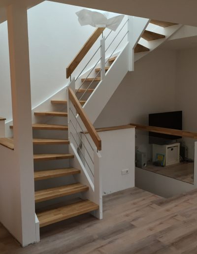Escalier traditionnel avec limon en bois blanc, marche en chênes, main courante en bois et tige horizontale en inoc