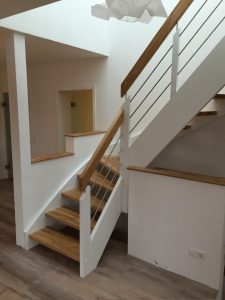 Escalier traditionnel avec limon en bois blanc, marche en chênes, main courante en bois et tige horizontale en inoc