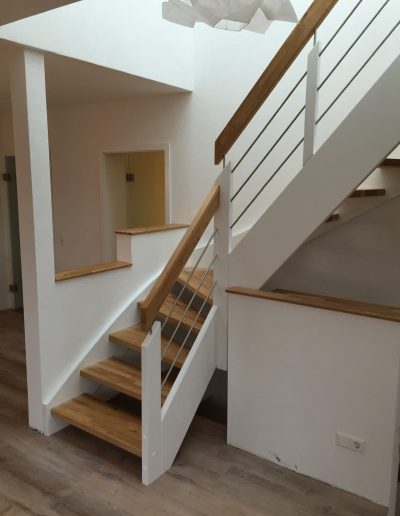 Escalier traditionnel avec limon en bois blanc, marche en chênes, main courante en bois et tige horizontale en inoc