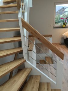 Escalier traditionnel avec limon en bois blanc, marche en chênes, main courante en bois et tige horizontale en inoc