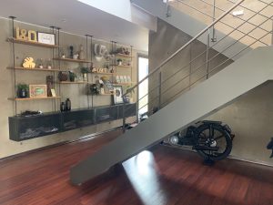 Escalier design industriel en acier gris avec marches en bois et garde-corps inox, poteaux plats et main courante ronde soudée. Escalier avec palier intérmédiaire