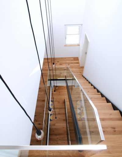 Escalier limon bois laqué tytpe industriel avec garde-corps full verre 16 mm sans poteaux marches en chêne