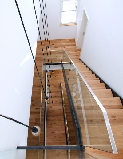Escalier limon bois laqué tytpe industriel avec garde-corps full verre 16 mm sans poteaux marches en chêne