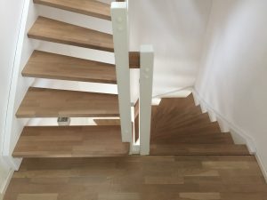 Escalier traditionnel avec limon en bois blanc, marche en chênes, main courante en bois et tige horizontale en inoc