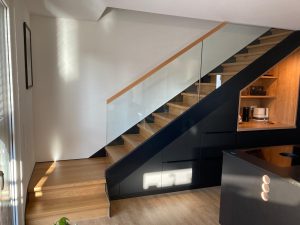 Meuble sous Escalier marche et contre marches en bois chêne entre limon bois laqué industriel et garde-corps en verre plein, finition main courante chêne, sans poteau