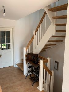 Escalier traditionnel en bois avec main courante et marches en chênes. Contre marche et limon laqué en blanc, ballustres bois