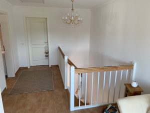 Escalier traditionnel en bois avec main courante et marches en chênes. Contre marche et limon laqué en blanc, ballustres bois