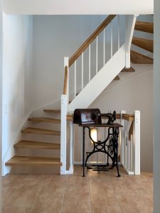 Escalier traditionnel en bois avec main courante et marches en chênes. Contre marche et limon laqué en blanc, ballustres bois