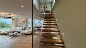 Garde-corps horizontal et rampant en full verre sans poteau apparant autour d'un escalier suspendu autoporteur design en bois