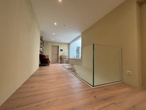 Garde-corps horizontal et rampant en full verre sans poteau apparant autour d'un escalier suspendu autoporteur design en bois