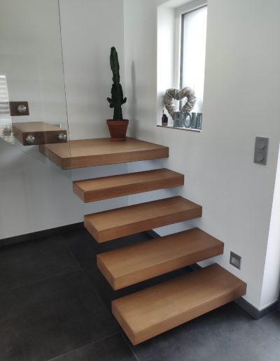 Escalier autoporteur marche flottante design epuré et aérien avec garde-corps rampant full verre en un quart tournant