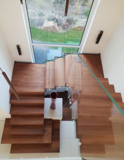Escalier autoporteur marche-contre-marche et marches flottante avec garde-corps full verre sans poteaux et marche pallière de départ