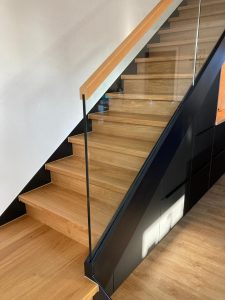 Escalier marche et contre marches en bois chêne entre limon bois laqué industriel et garde-corps en verre plein, finition main courante chêne, sans poteau