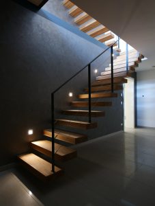 garde-corps rampant en acier plat laqué gris antracite et cable horizontal en inox autour d'une scalier autoporteur en bois