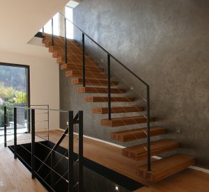 garde-corps rampant en acier plat laqué gris antracite et cable horizontal en inox autour d'une scalier autoporteur en bois