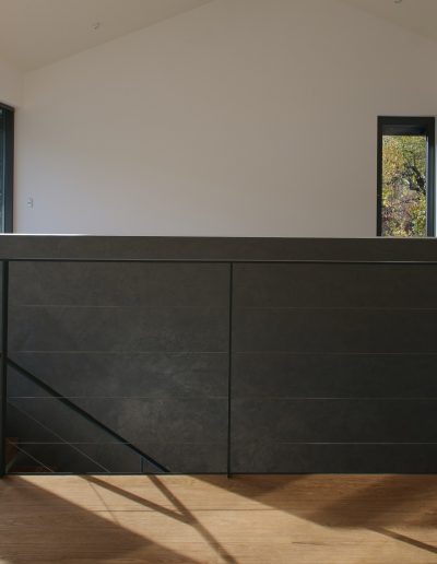 garde-corps horizontale autour de la trémie en acier plat laqué gris antracite et cable horizontal en inox autour d'une scalier autoporteur en bois