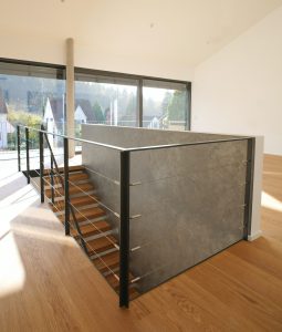 garde-corps horizontale autour de la trémie en acier plat laqué gris antracite et cable horizontal en inox autour d'une scalier autoporteur en bois