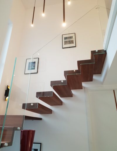 Escalier autoporteur marche-contre-marche et marches flottante avec garde-corps full verre sans poteaux et marche pallière de départ