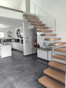 Escalier autoporteur marche flottante design epuré et aérien avec garde-corps rampant full verre en un quart tournant