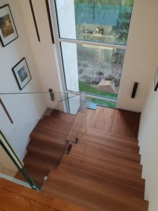 Escalier autoporteur marche-contre-marche et marches flottante avec garde-corps full verre sans poteaux et marche pallière de départ