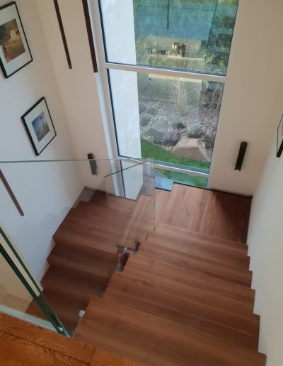 Escalier autoporteur marche-contre-marche et marches flottante avec garde-corps full verre sans poteaux et marche pallière de départ