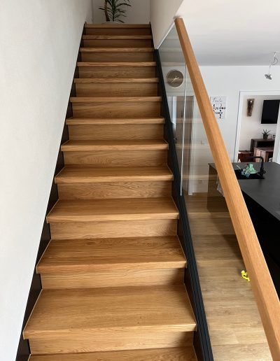Escalier marche et contre marches en bois chêne entre limon bois laqué industriel et garde-corps en verre plein, finition main courante chêne, sans poteau