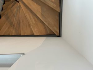 Escalier moderne bois métal type industriel avec limon en acier laqué, garde-corps en fer plat et finition main courante bois soudé et remplissage cables inox et verre en aprtie basse