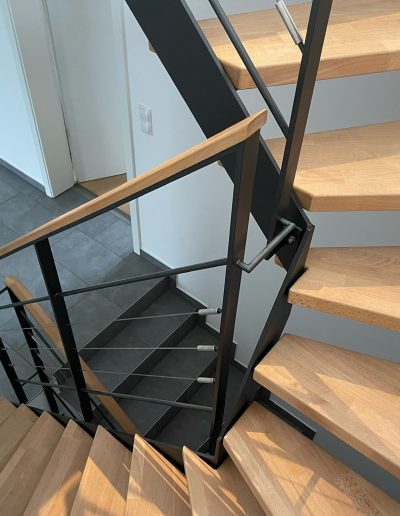 Escalier moderne bois métal type industriel avec limon en acier laqué, garde-corps en fer plat et finition main courante bois soudé et remplissage cables inox et verre en aprtie basse