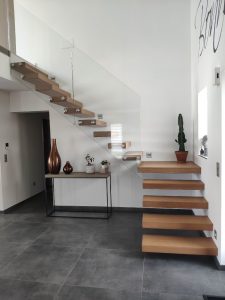 Escalier autoporteur marche flottante design epuré et aérien avec garde-corps rampant full verre en un quart tournant