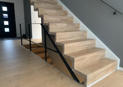 Escalier design à Wolfersdorf: marche et contremarche en chêne abouté, garde-corps en acier plat soudé et laqué en noir