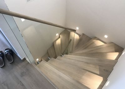 Escalier design à Pfulgrisheim: design marche contre marches en deux quarts tournant, avec garde-corps full verre et finition maincourante bois