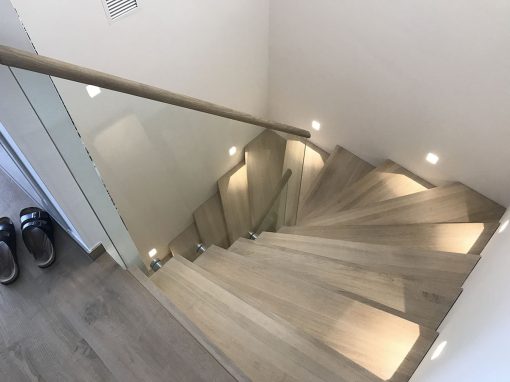 Escalier design à Pfulgrisheim: design marche contre marches en deux quarts tournant, avec garde-corps full verre et finition maincourante bois